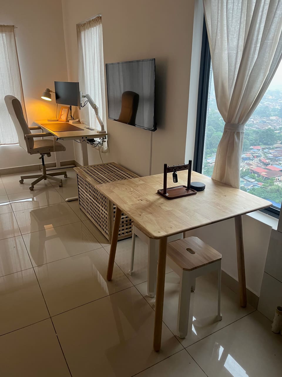 Dining table by the window with the desk area in the background